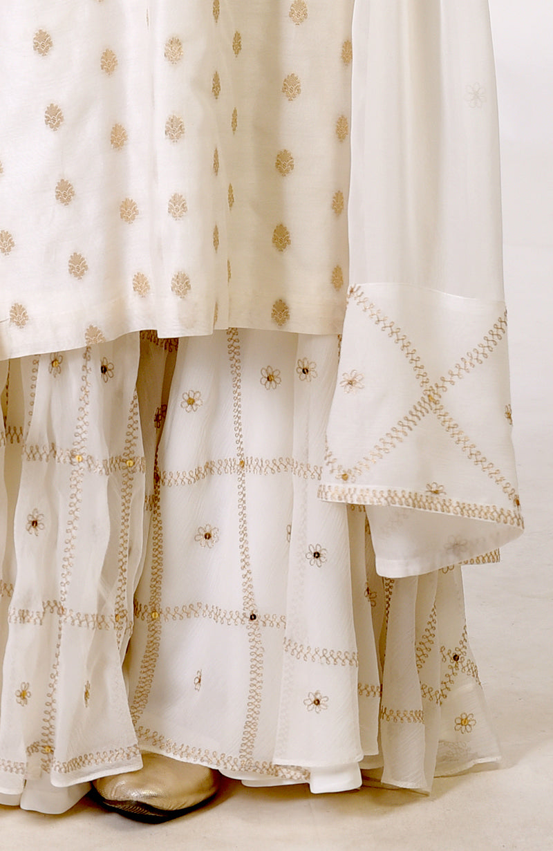 Ivory Banarasi Bootah and Aari Tilla Embroidered Sharara Set with gold shoes.
