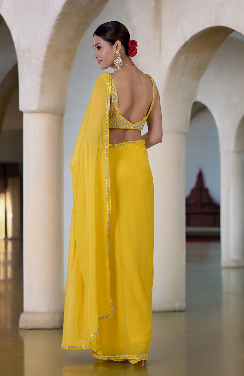 A woman in a daffodil yellow hand-embroidered saree with a beaded blouse.