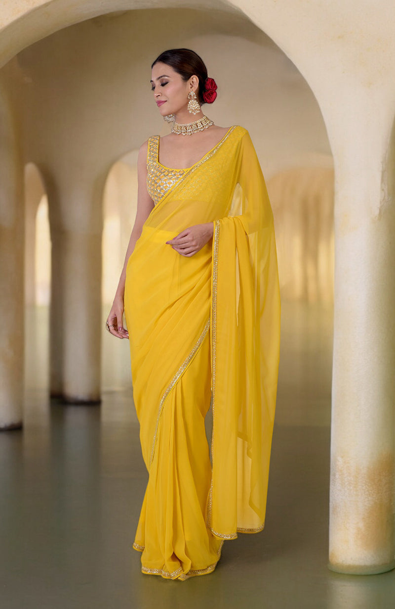 A woman in a daffodil yellow hand-embroidered saree with a matching beaded blouse.