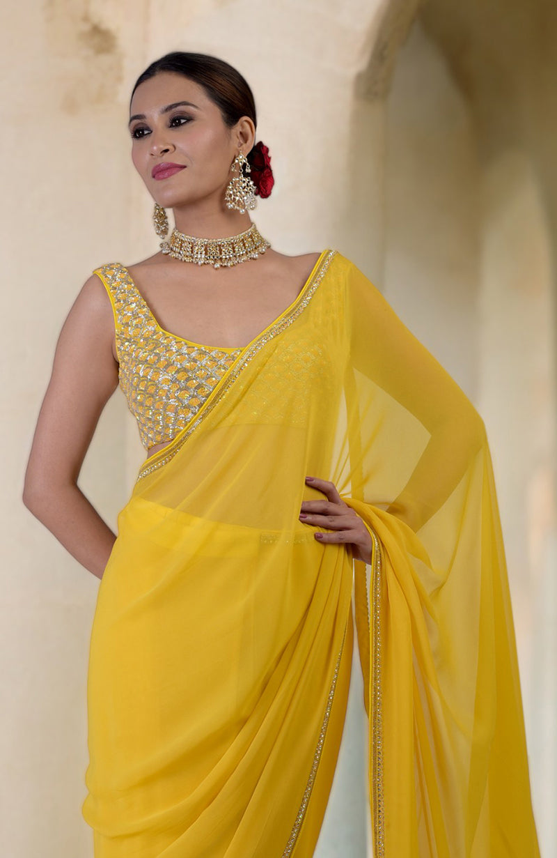 A woman in a daffodil yellow hand-embroidered saree with a beaded blouse.