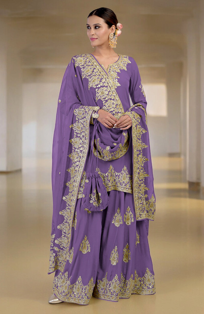 A woman models a purple sharara set with gold embroidery and a matching potli bag.