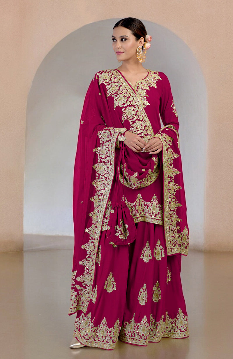 A woman models a bright rose gold Kashmiri Tilla and Zardozi hand-embroidered sharara set.