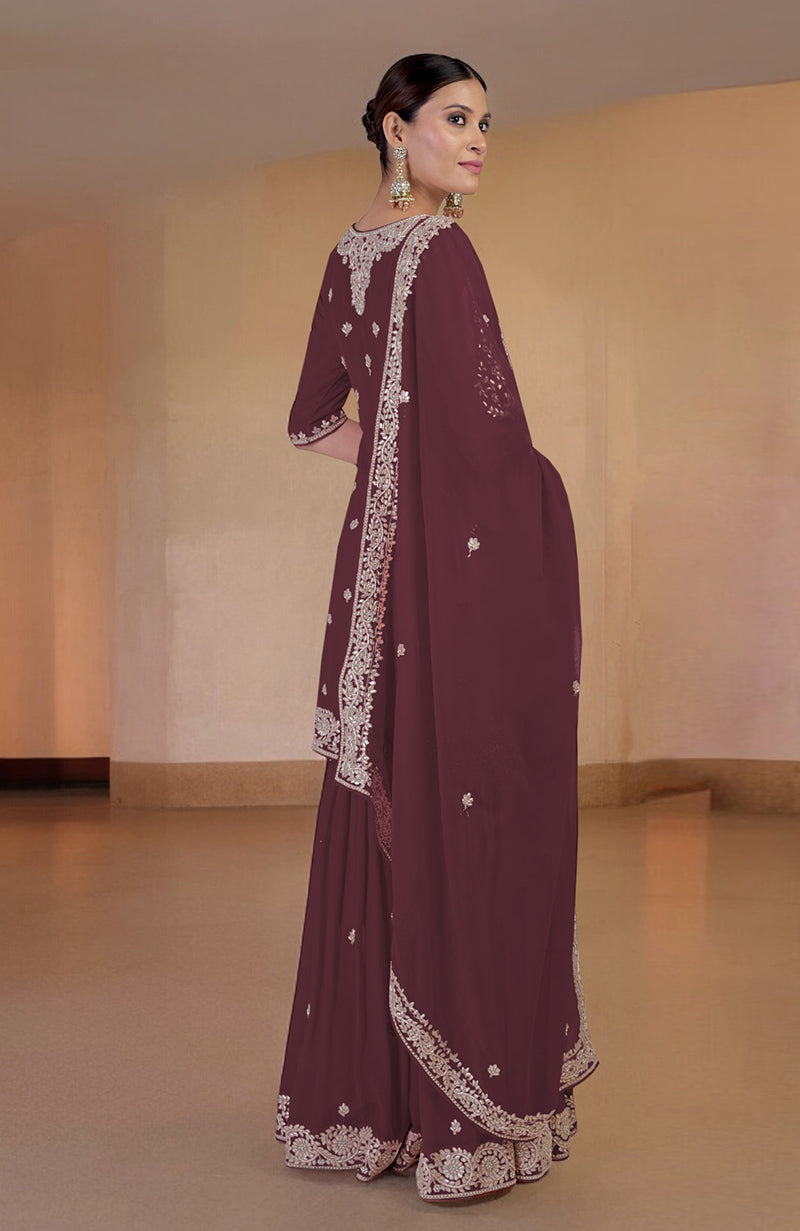 A woman models a burgundy sharara set with intricate embroidery.
