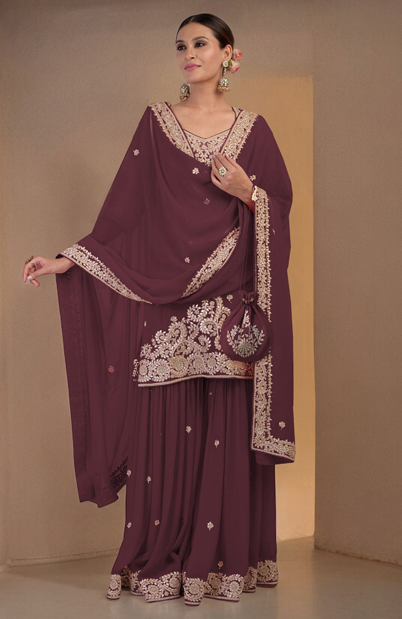 A woman models a burgundy sharara set with gold embroidery and a matching potli bag.