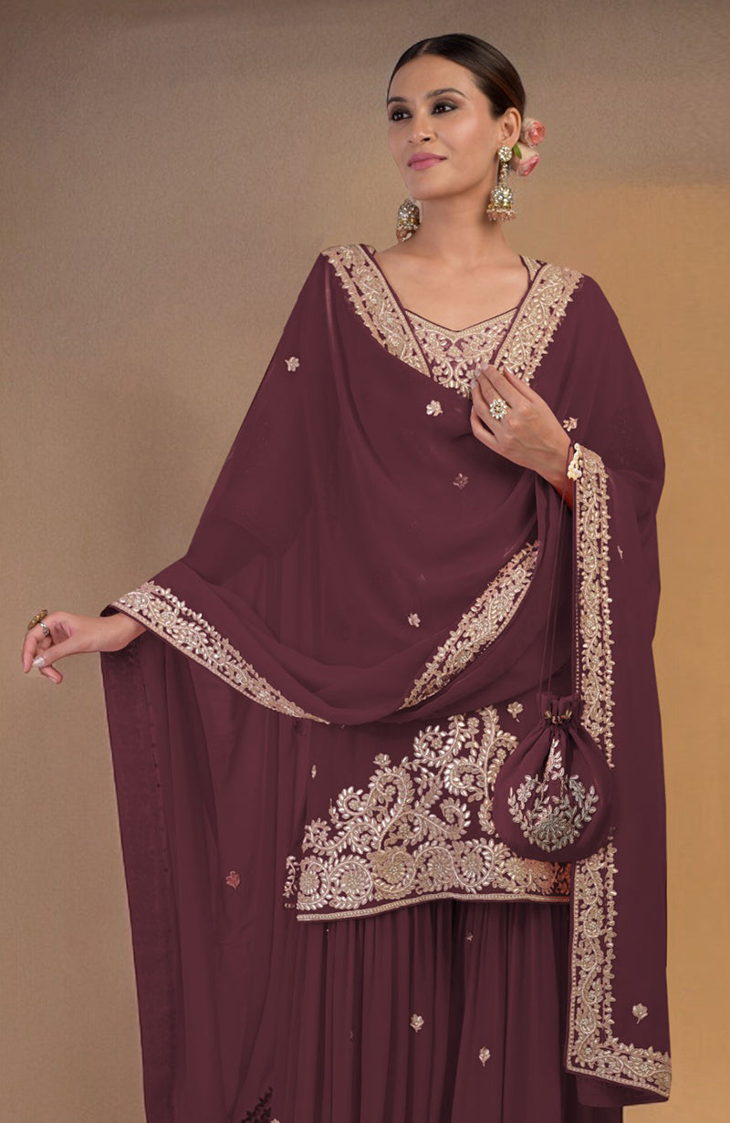 A woman models a burgundy sharara set with gold embroidery and a matching potli bag.