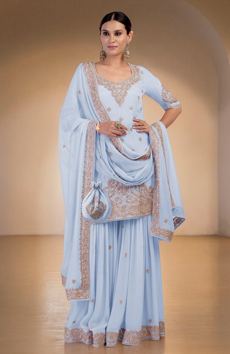 Illusion blue sharara set with intricate rose gold embroidery and a matching potli bag.