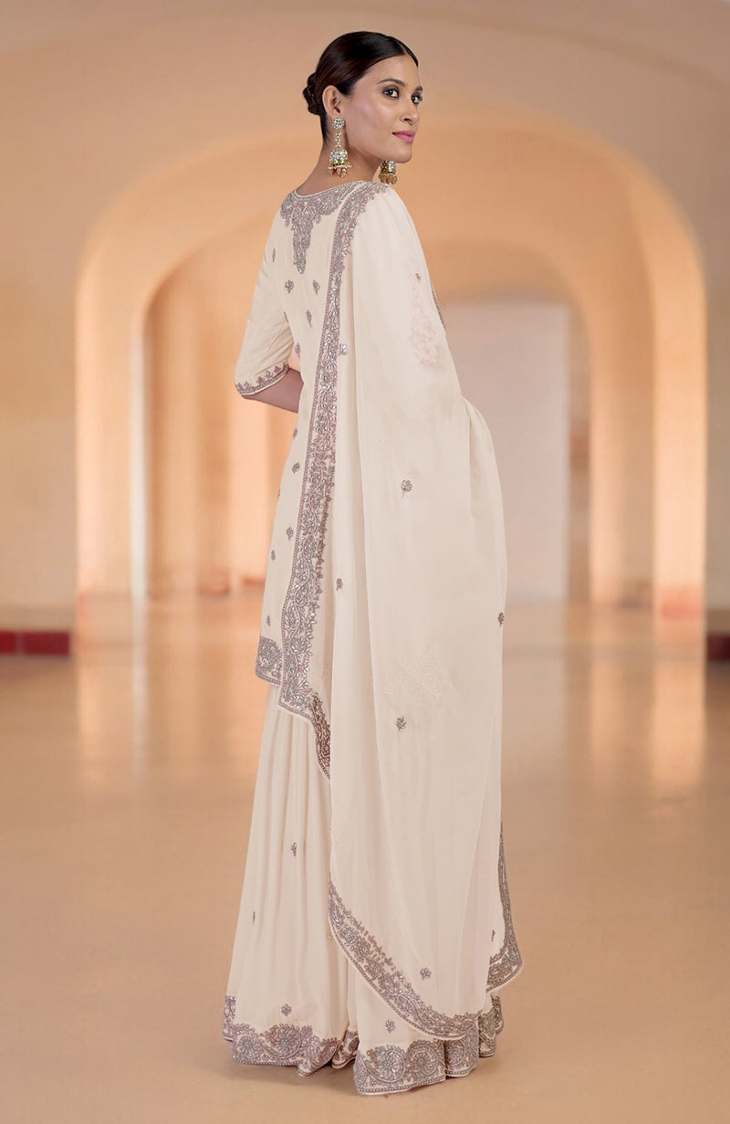 A woman models a sea salt sharara set with intricate embroidery.