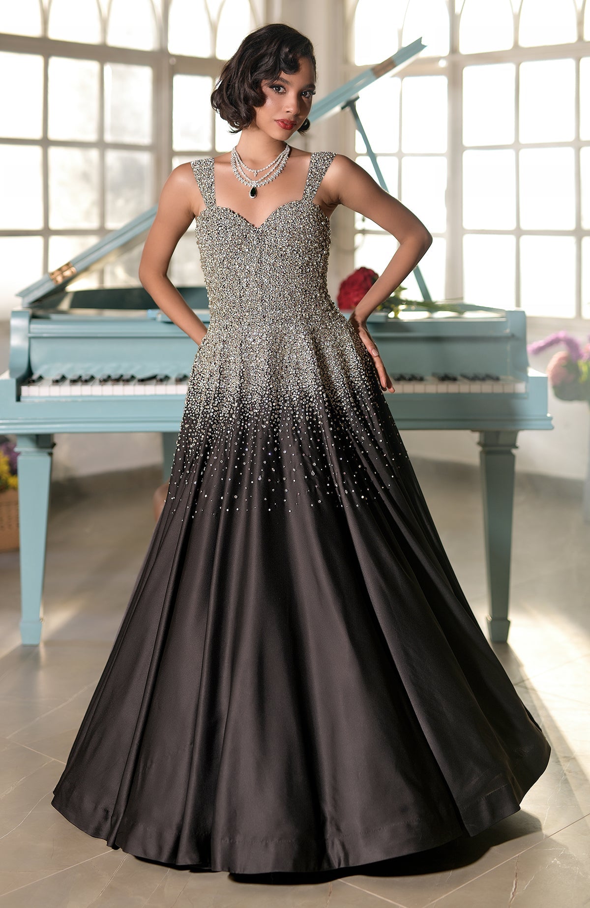 A woman models a black and silver crystal-embroidered princess gown.