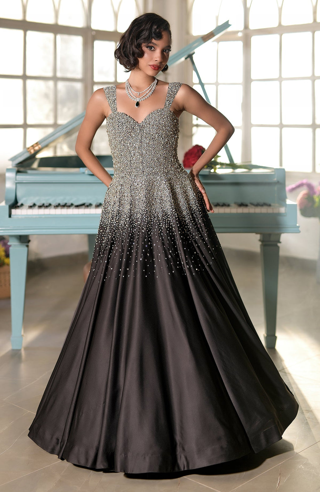 A woman models a black and silver crystal-embroidered princess gown.