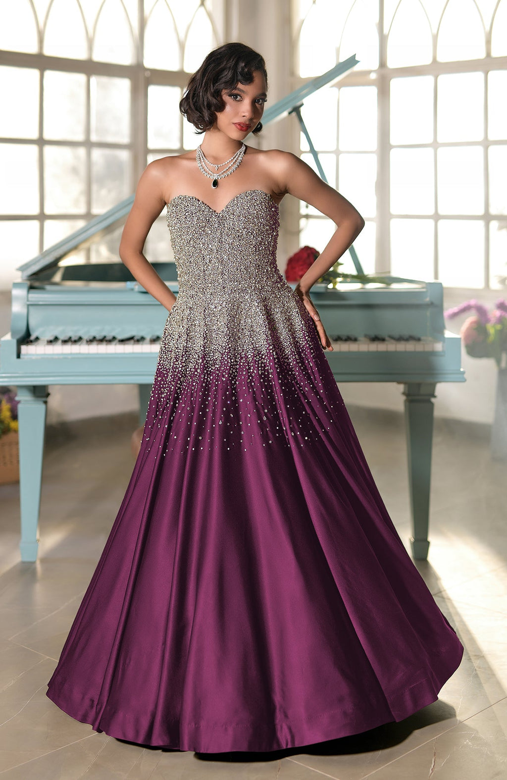A woman in a strapless, crystal-embroidered gown with a purple ombré skirt.