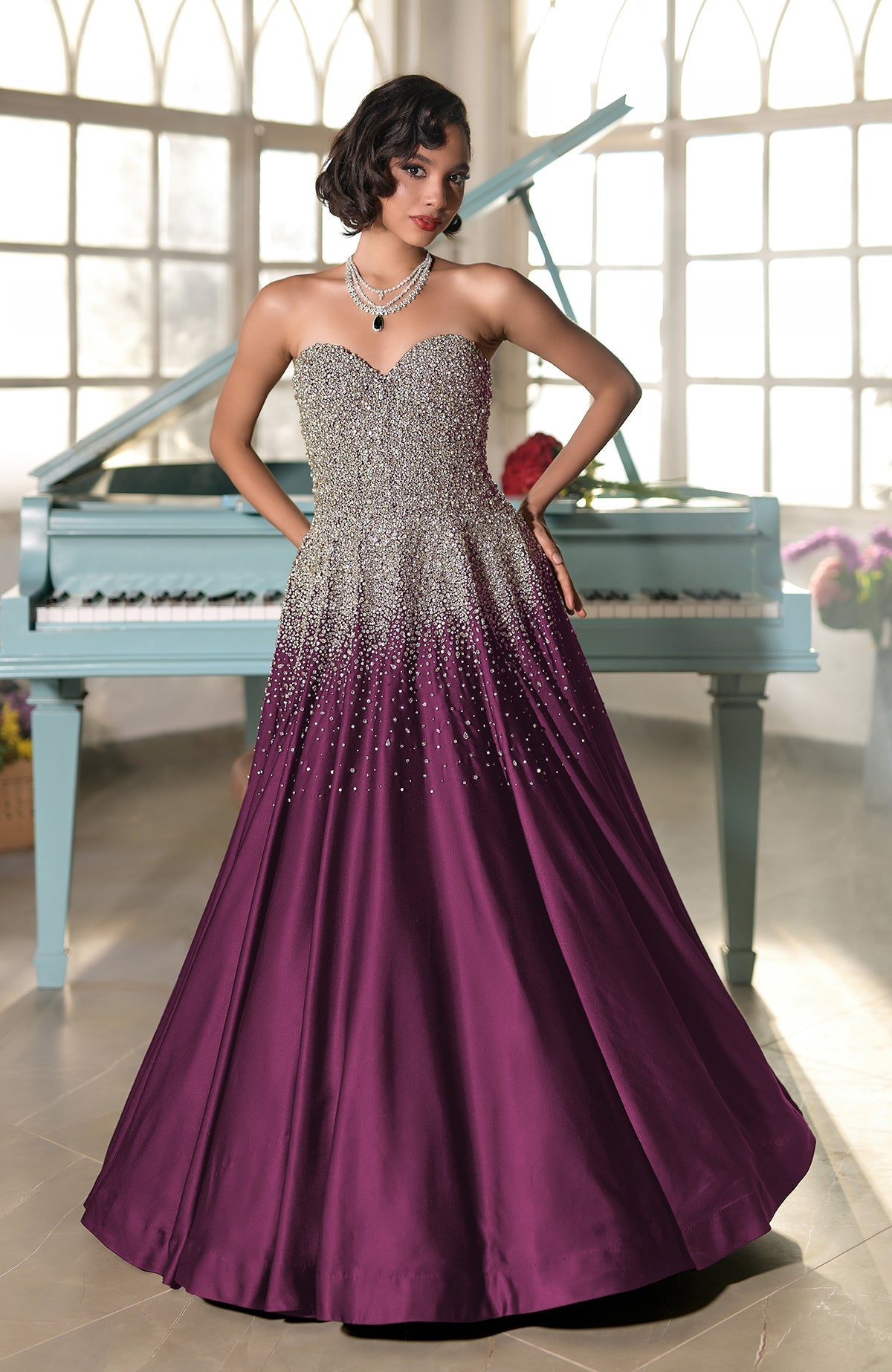 A woman in a strapless, crystal-embroidered gown with a purple ombré skirt.