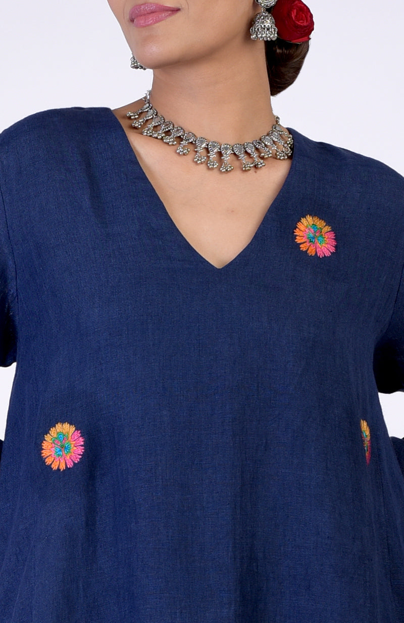 Navy blue linen kurta with colorful Kashida embroidery and a silver necklace.