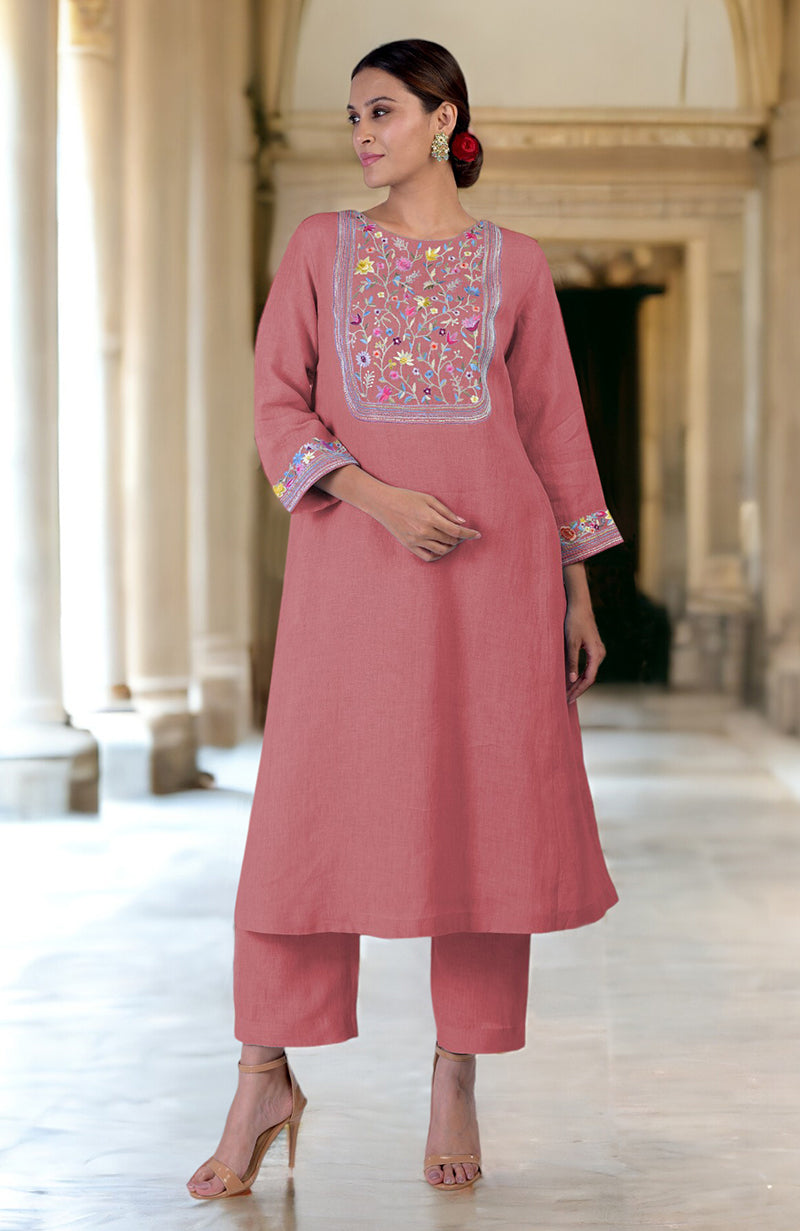 A woman models a desert rose linen kurta set with Parsi Gara embroidery.