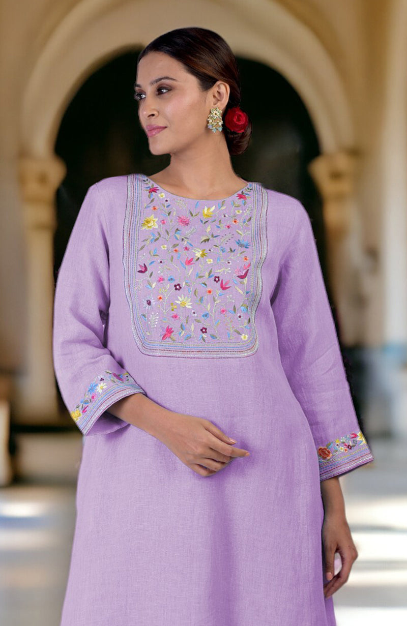 A woman models a lilac linen kurta with colorful Parsi Gara embroidery on the neckline and sleeves.