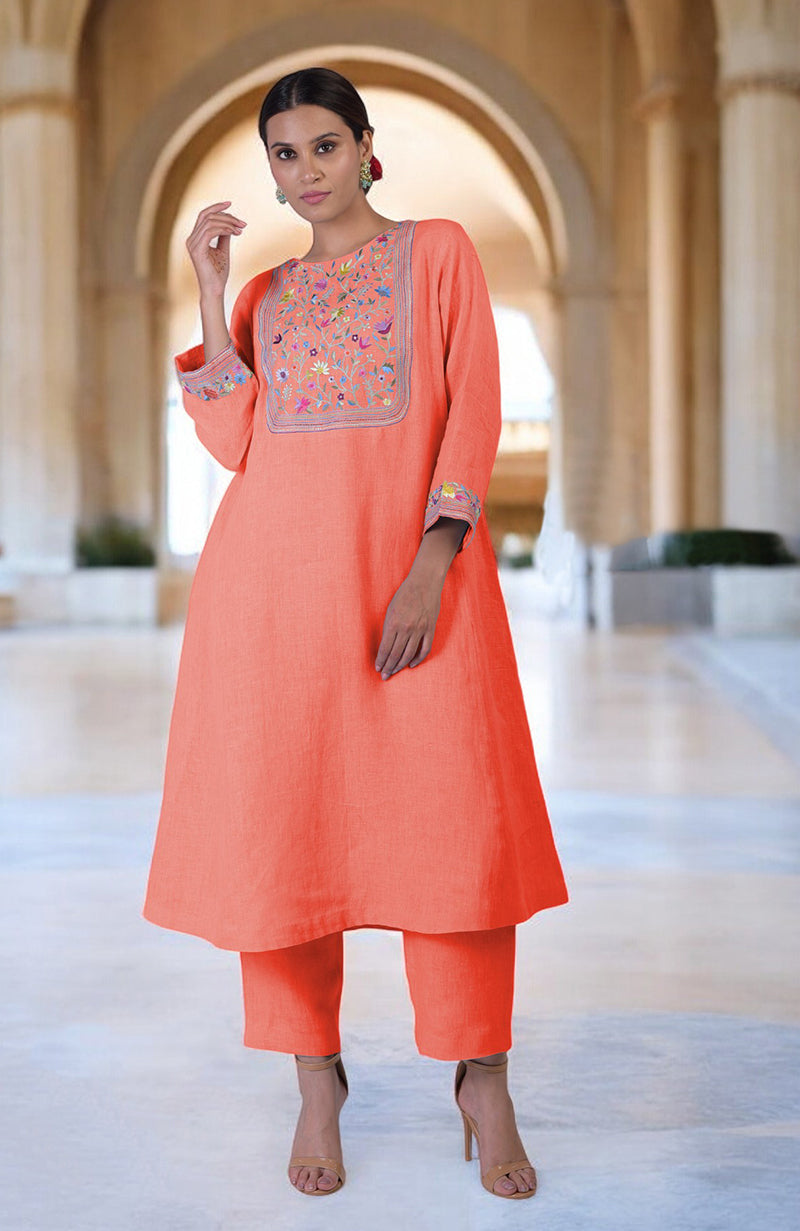 A woman models a living coral Parsi Gara embroidered linen kurta set.