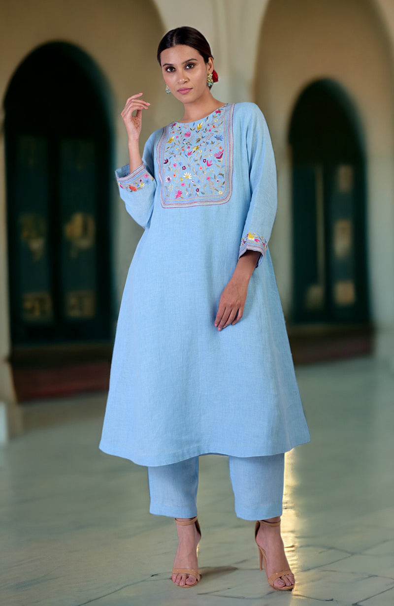 Cerulean blue Parsi Gara embroidered linen kurta set with a woman modeling it.