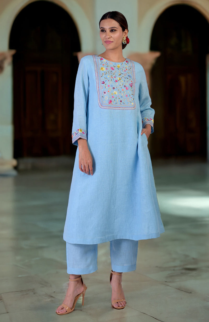 Cerulean blue Parsi Gara embroidered linen kurta set with a woman modeling it.