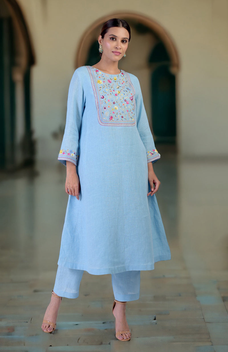 Cerulean blue Parsi Gara embroidered linen kurta set with a woman modeling it.