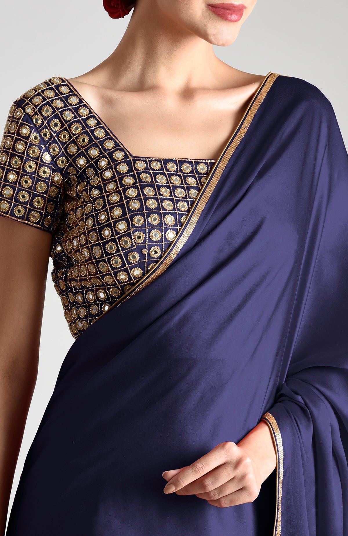 A woman models a midnight blue saree with a mirror and zardozi embroidered blouse.
