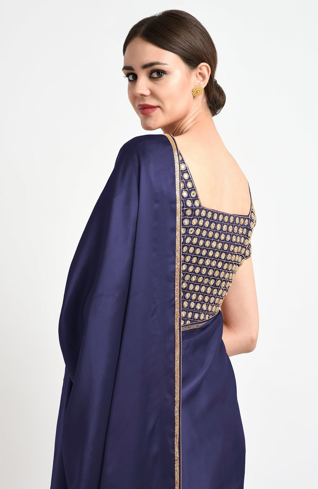 A woman in a midnight blue mirror work and zardozi hand-embroidered saree.