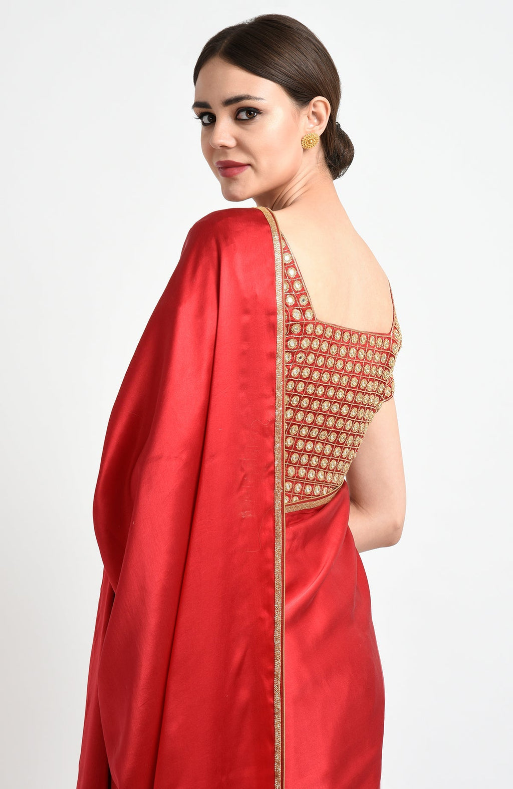 A woman in a red satin silk saree with mirror and zardozi embroidery.