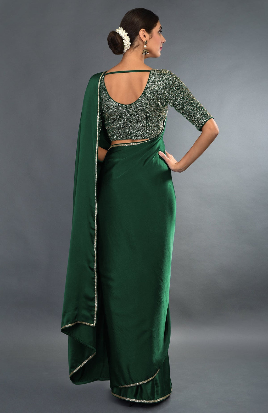 Emerald green satin saree and blouse with gold zardozi embroidery.