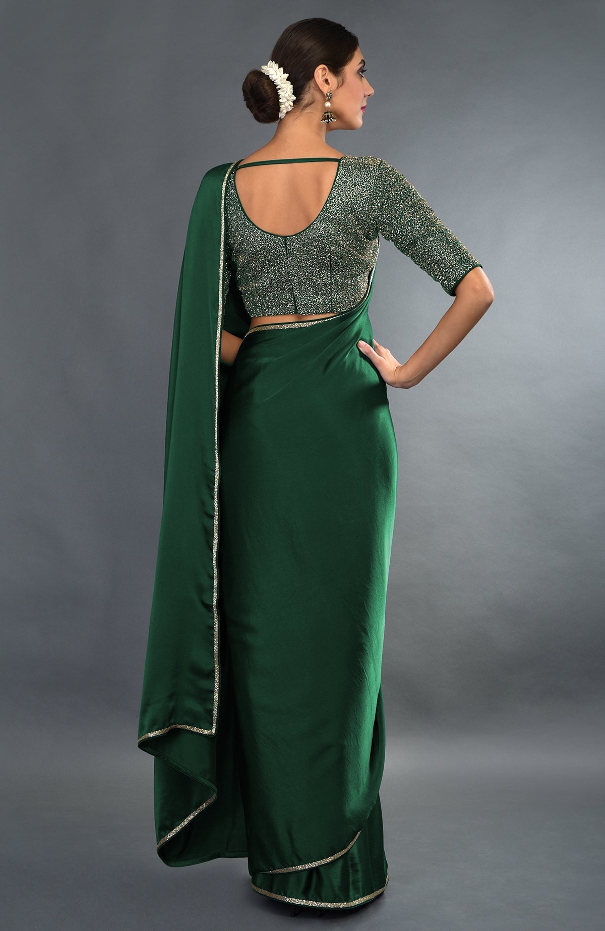 Emerald green satin saree and blouse with gold zardozi embroidery.