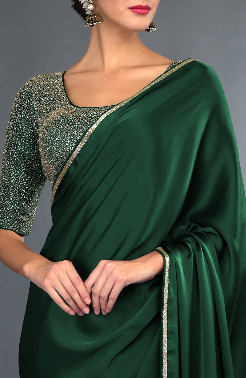 Emerald green satin saree with gold zardozi embroidery and matching blouse.