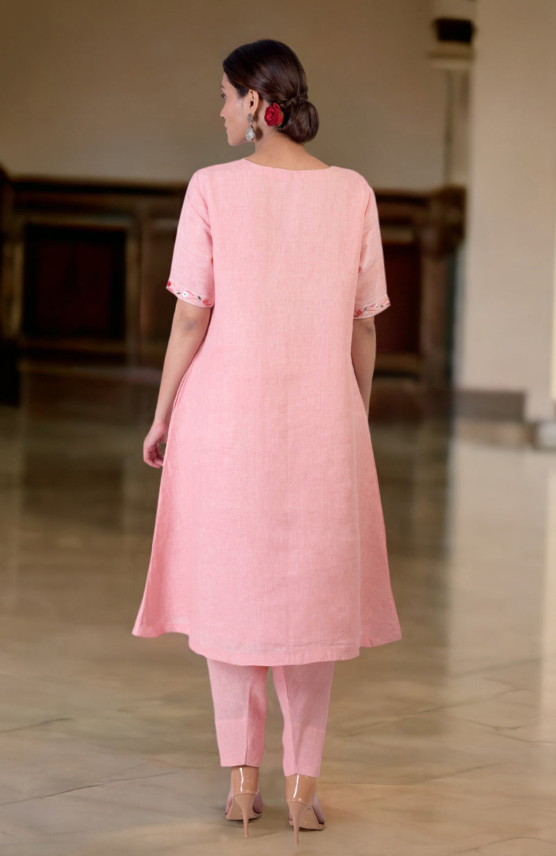 A woman from behind wears a pink linen kurta set with Parsi Gara embroidery.