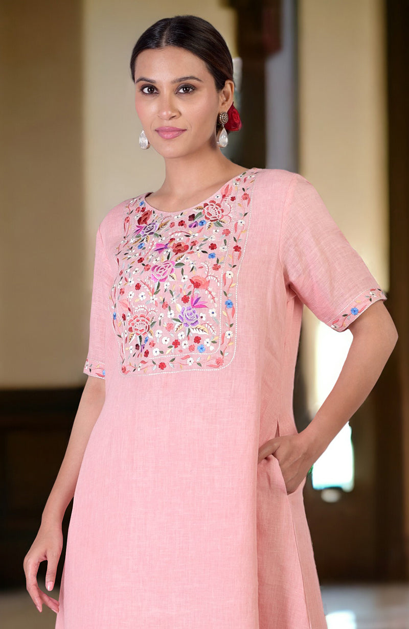 Pink linen kurta with colorful Parsi Gara embroidery on the front and sleeves.