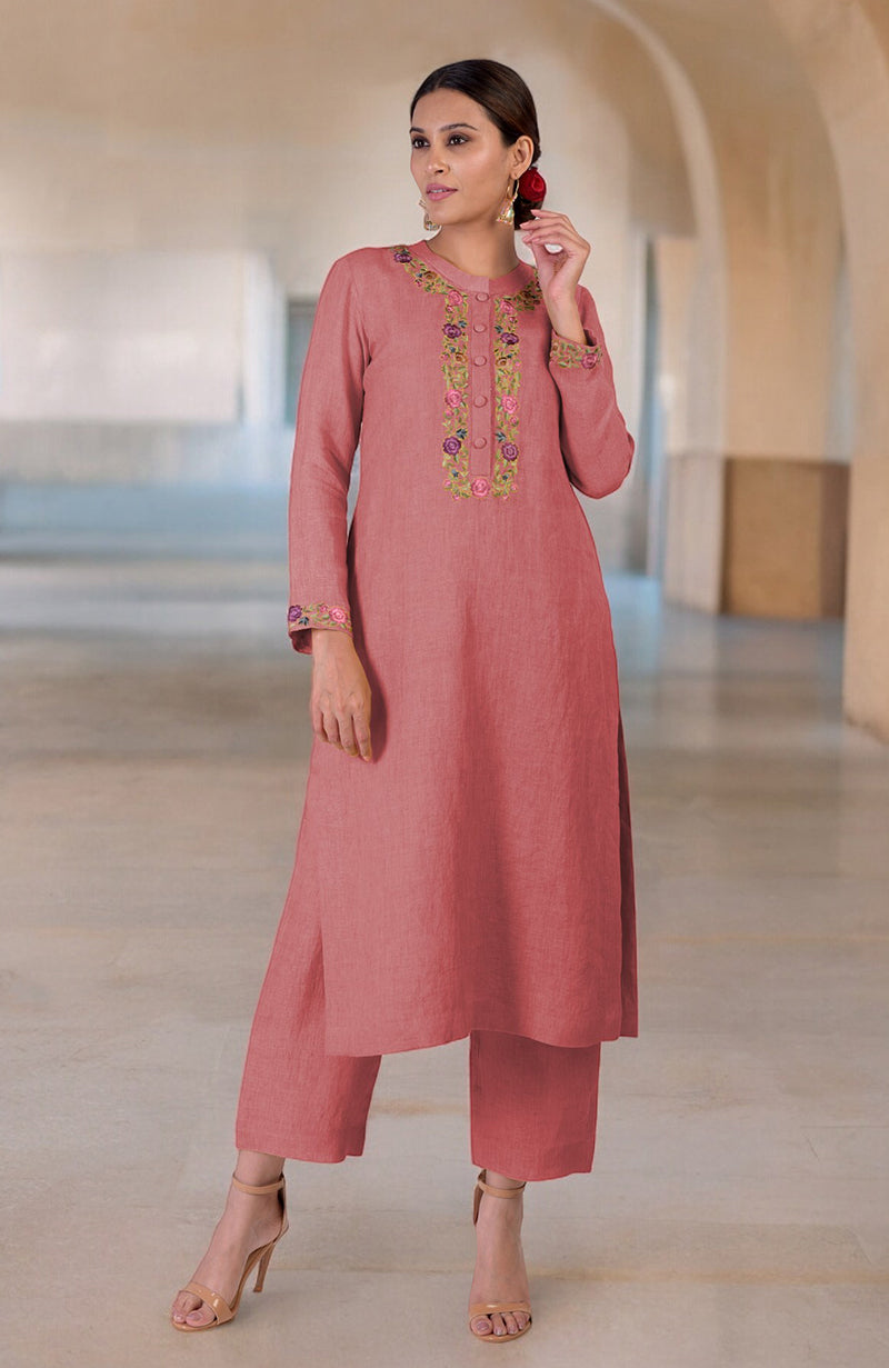 A woman models a desert rose linen kurta set with Parsi Gara embroidery.