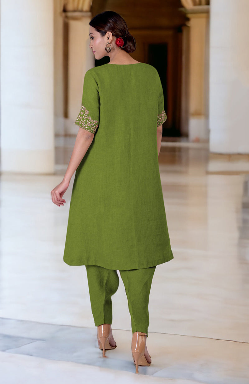 A woman from behind wears a green linen kurta set with embroidered sleeves and nude heels.