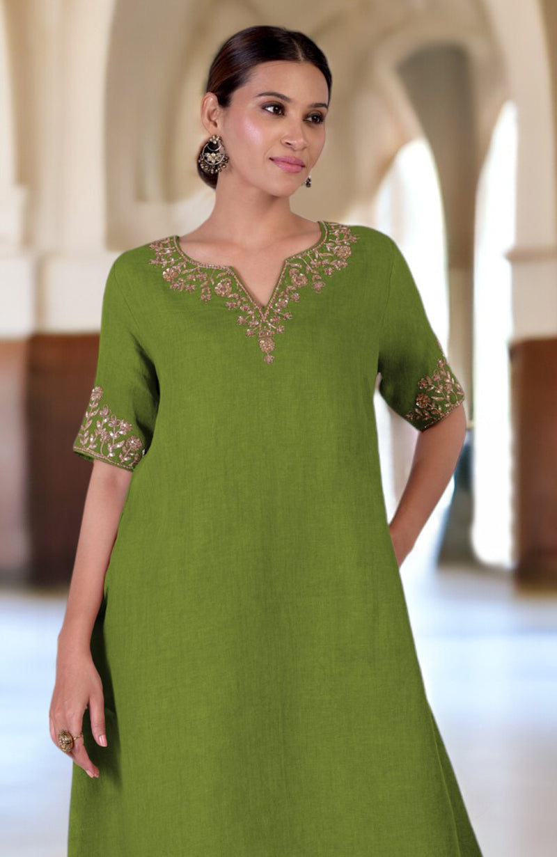 A woman models a green linen kurta with Marori embroidery on the neckline and sleeves.