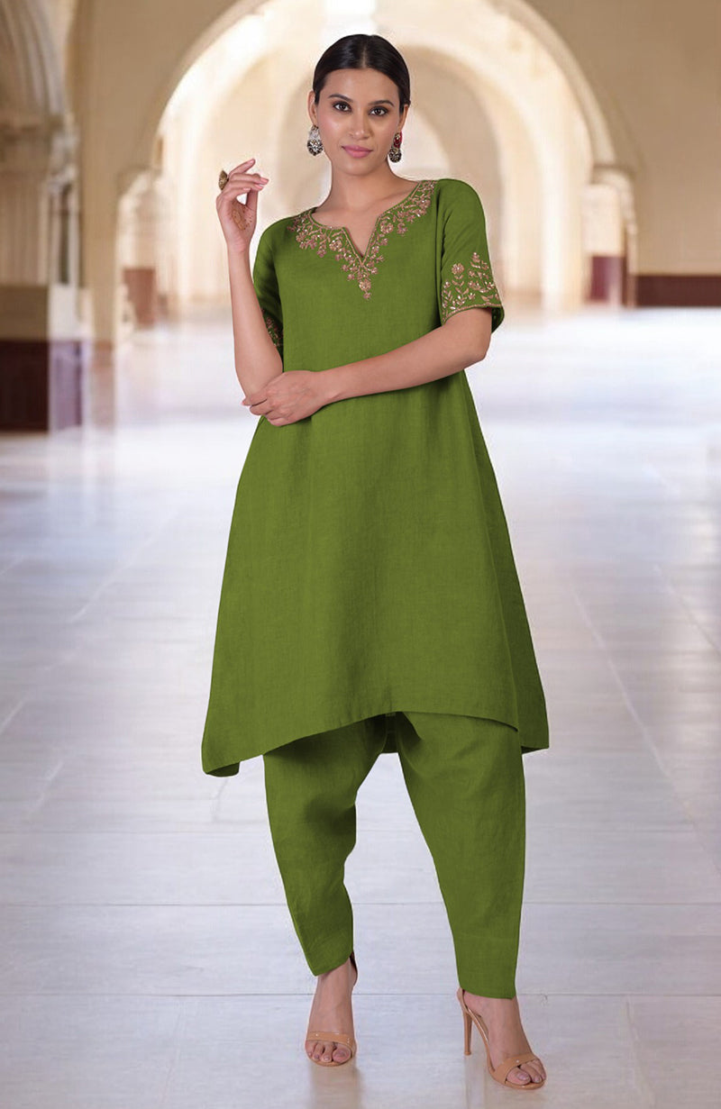 A woman models a green linen kurta set with Marori embroidery and a high-low hem.
