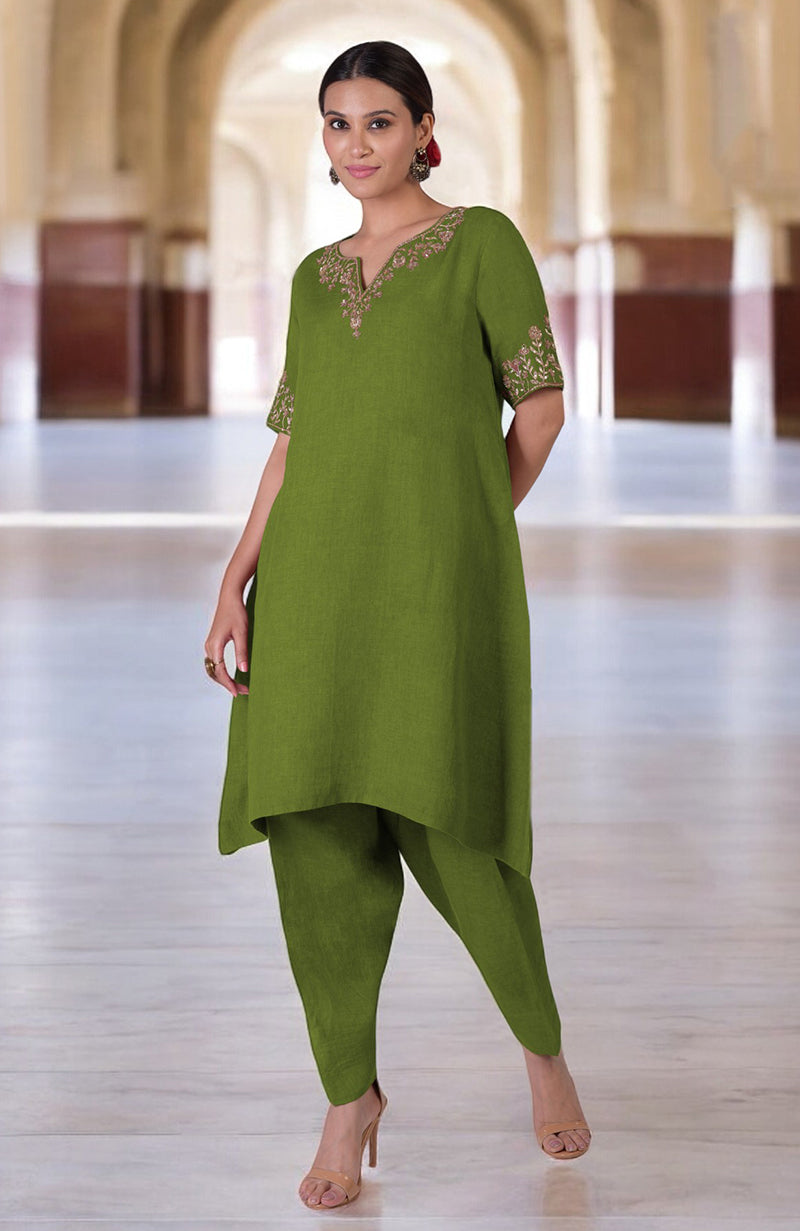 A woman models a green linen kurta set with Marori embroidery on the neckline and sleeves.