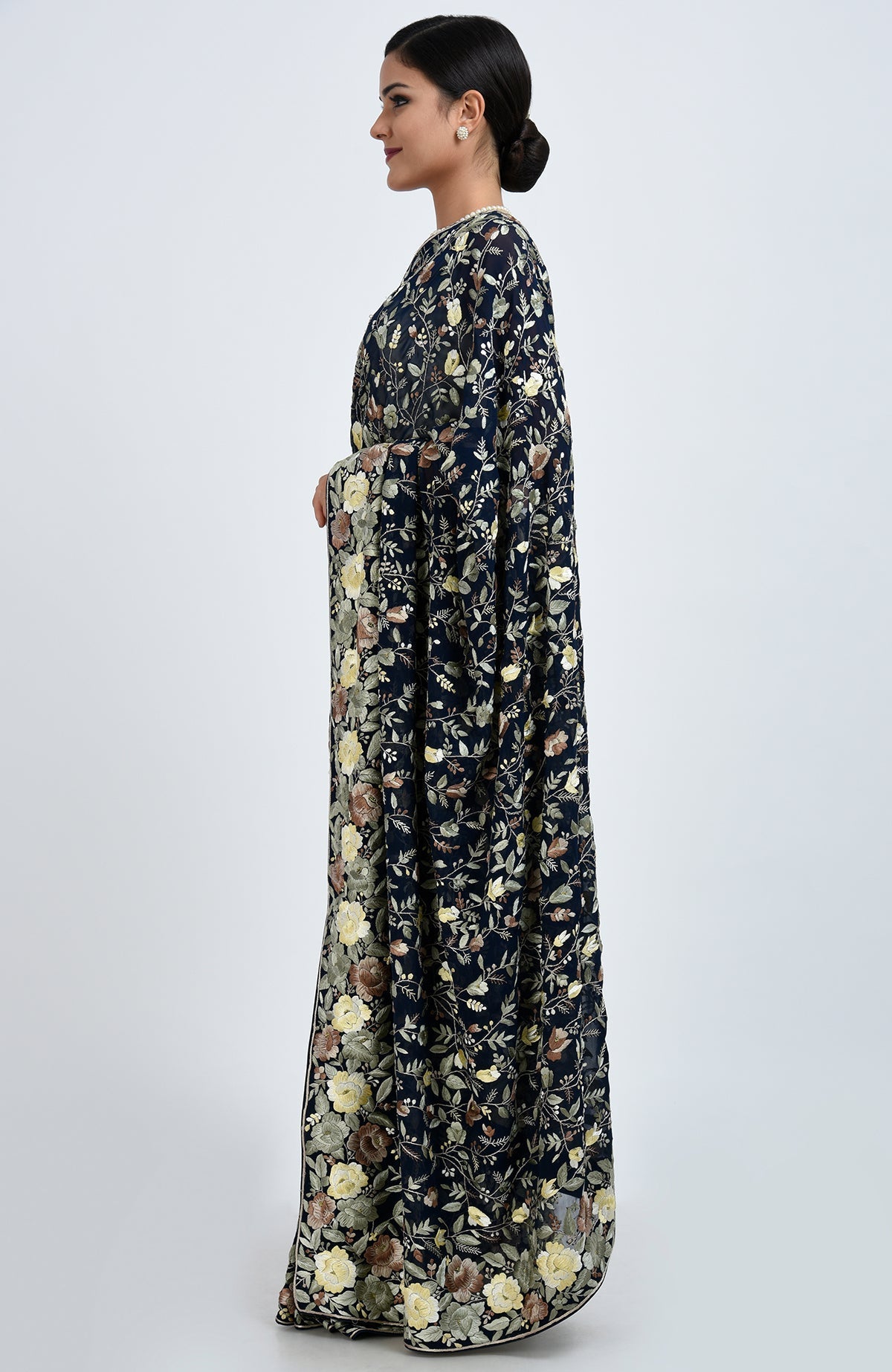 A woman models a midnight blue Parsi Gara hand-embroidered saree with floral patterns.