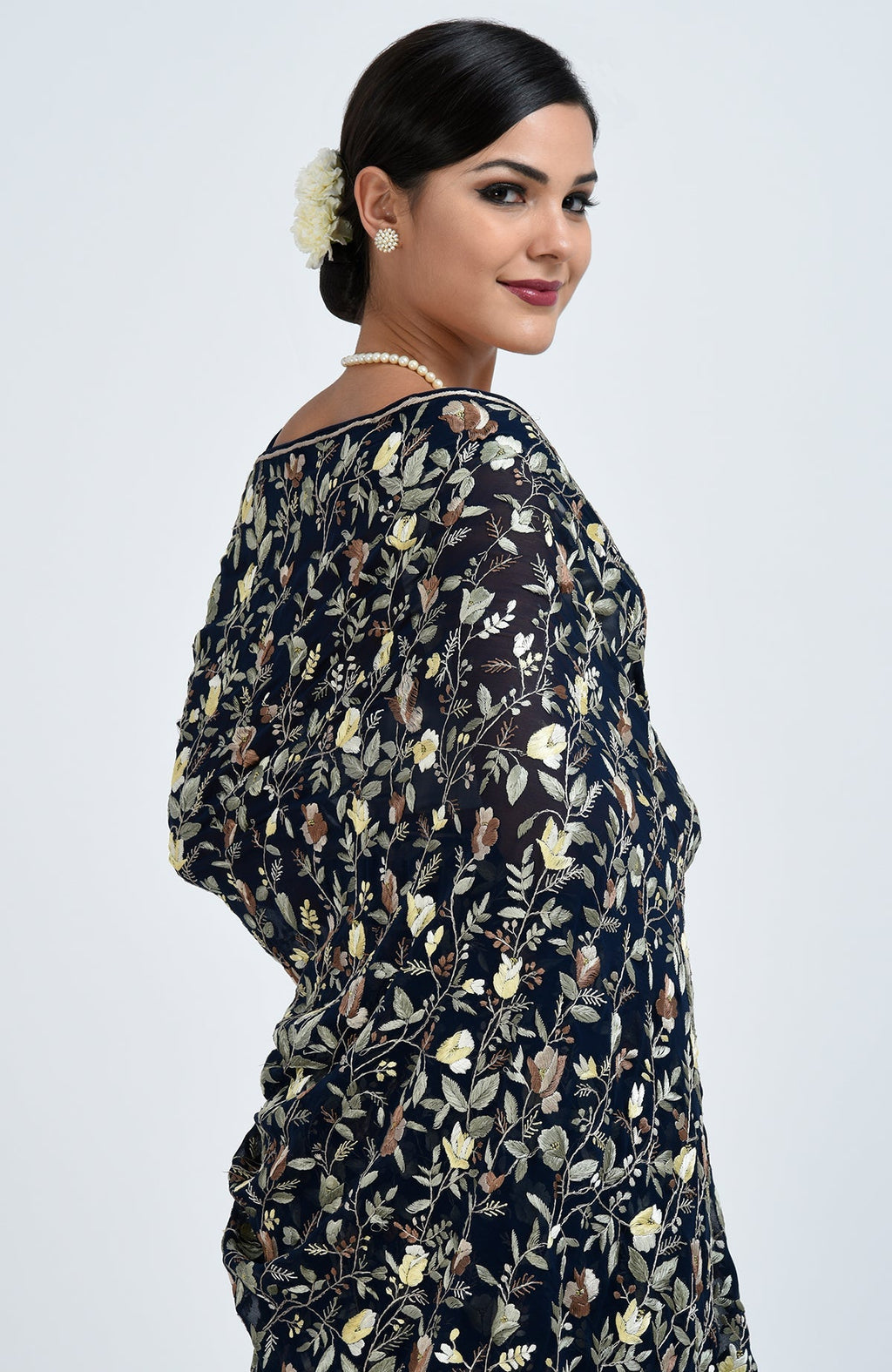Woman in a midnight blue Parsi Gara hand-embroidered saree with floral patterns.