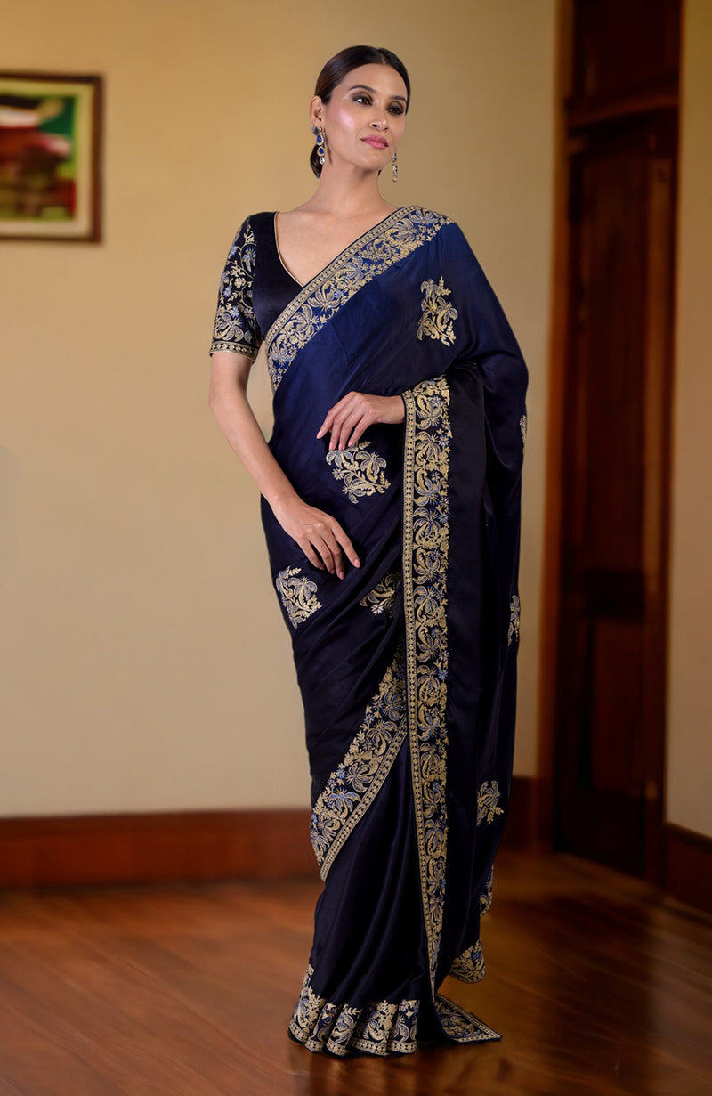 A woman models a midnight blue ombre Kashidakari embroidered saree with a matching blouse.