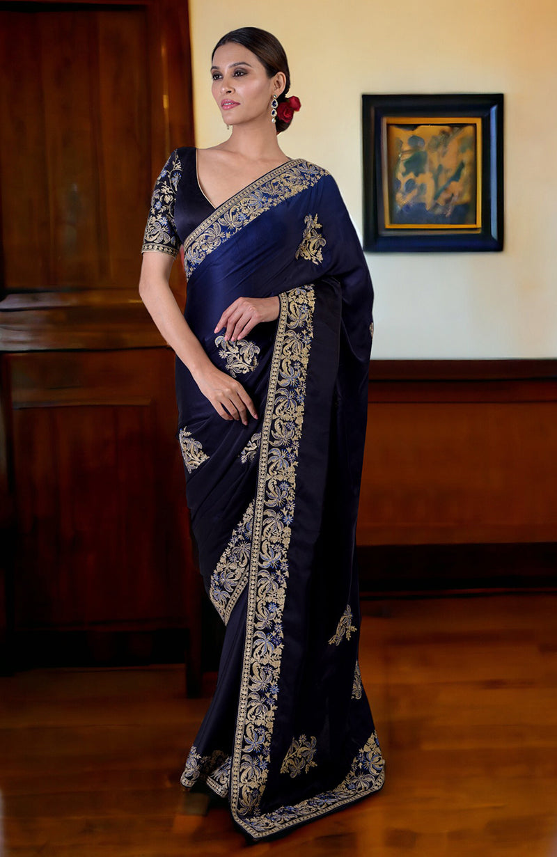 A woman models a midnight blue ombre Kashidakari embroidered saree with a matching blouse.