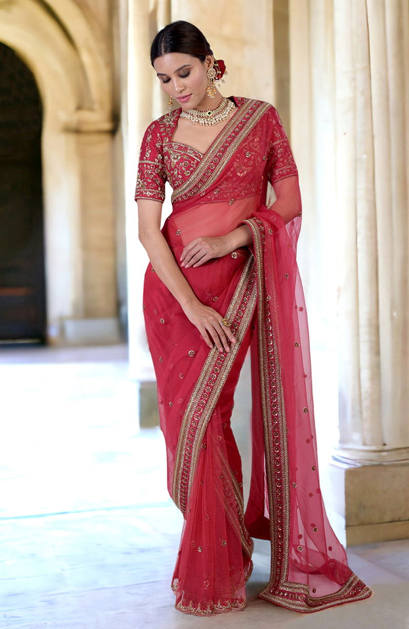 A model poses in a ruby red zardozi hand-embroidered saree with a matching blouse.