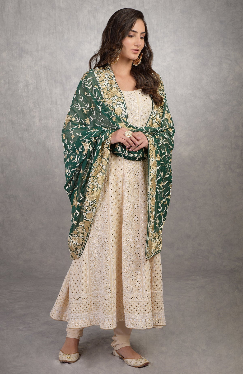 A woman models a champagne chikankari suit with a green Parsi Gara dupatta.