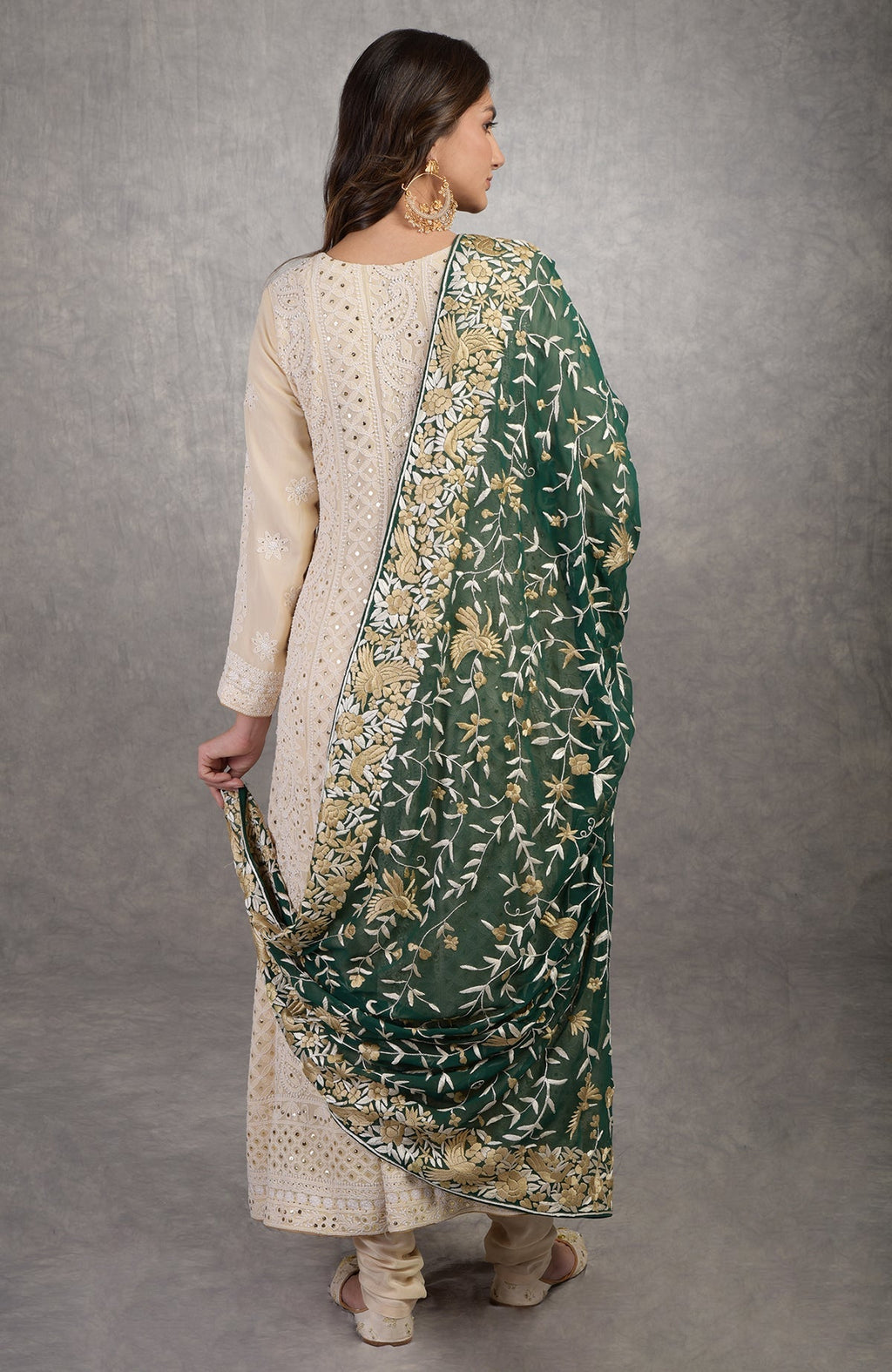 A woman models a champagne chikankari suit with a green Parsi Gara dupatta.