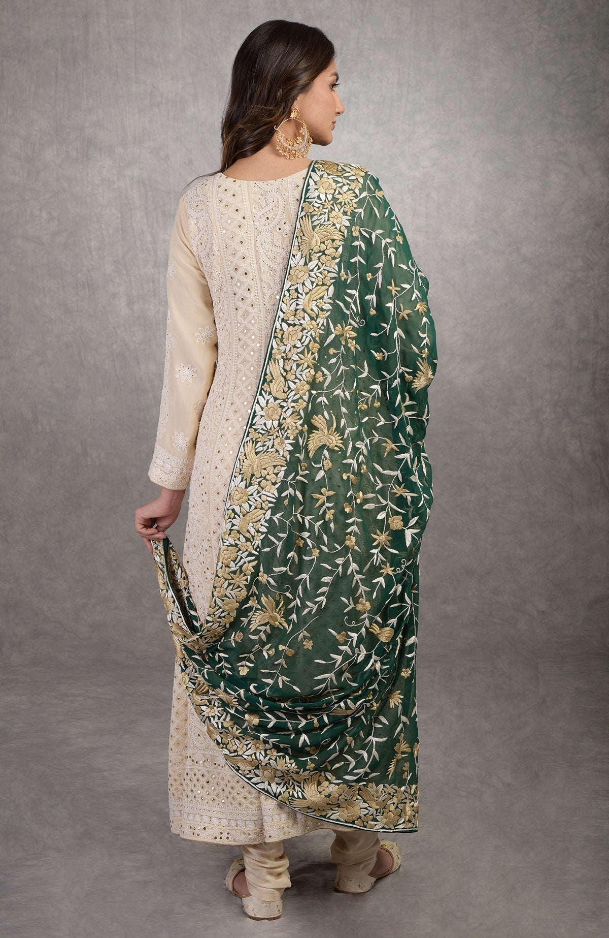 A woman models a champagne chikankari suit with a green Parsi Gara dupatta.