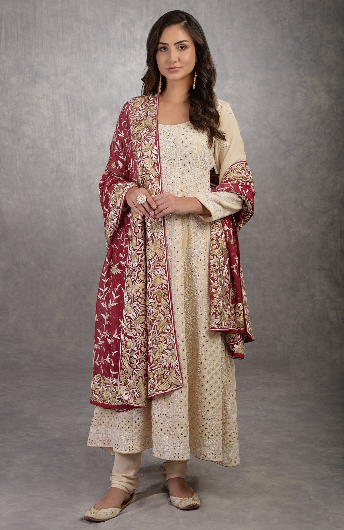 A woman models a champagne chikankari suit with a red Parsi Gara dupatta.