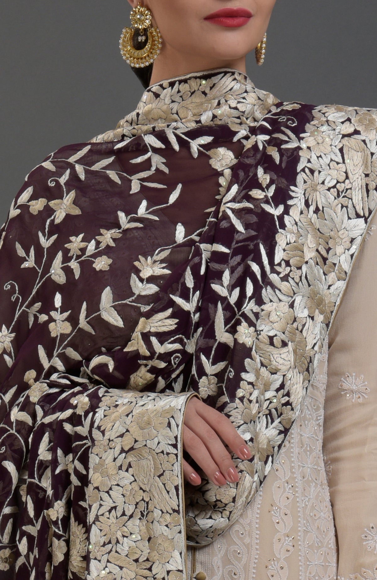 A woman models a champagne chikankari suit with a Parsi Gara hand-embroidered dupatta.