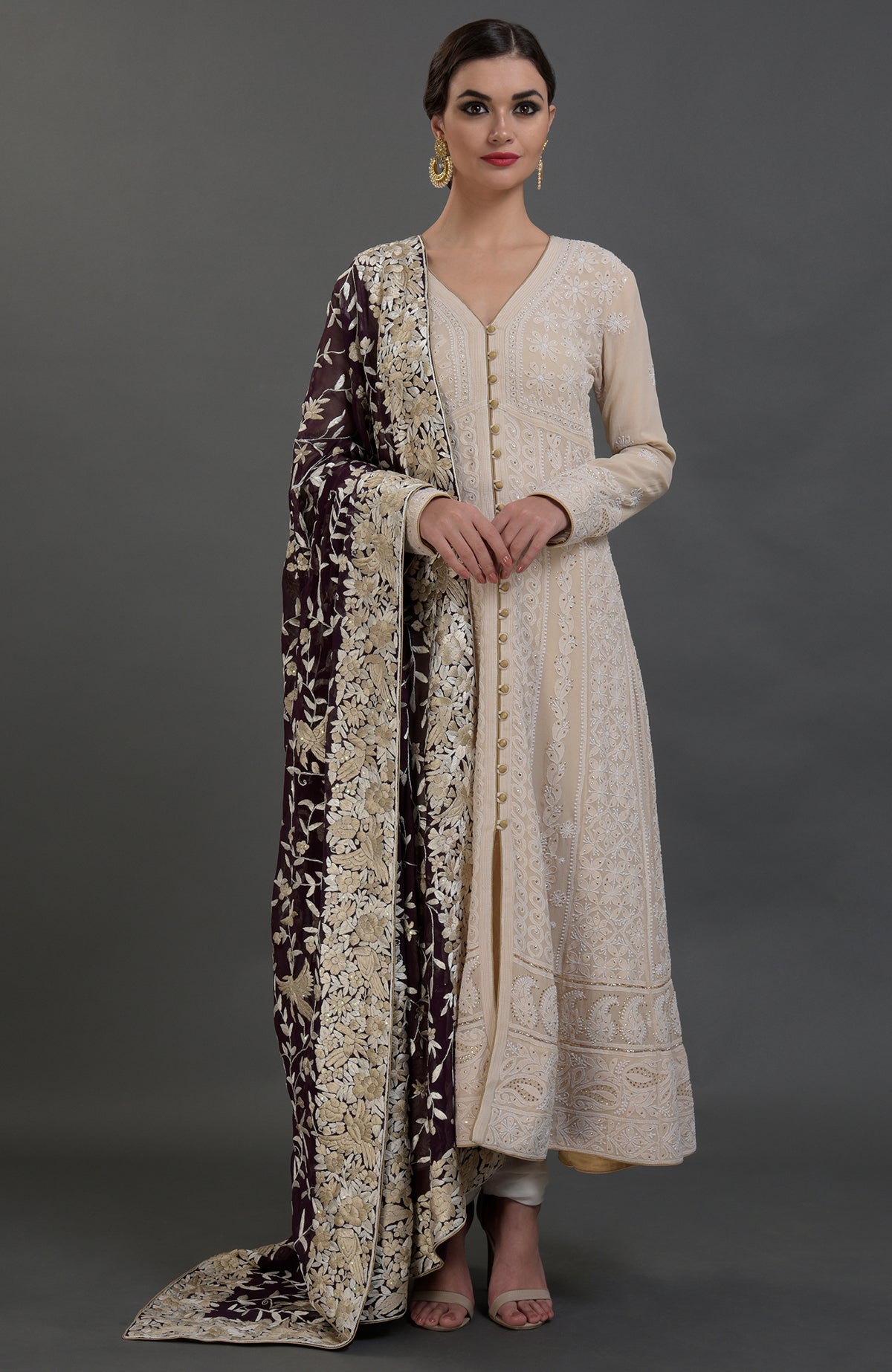 A woman models a champagne chikankari suit with a Parsi Gara hand-embroidered dupatta.