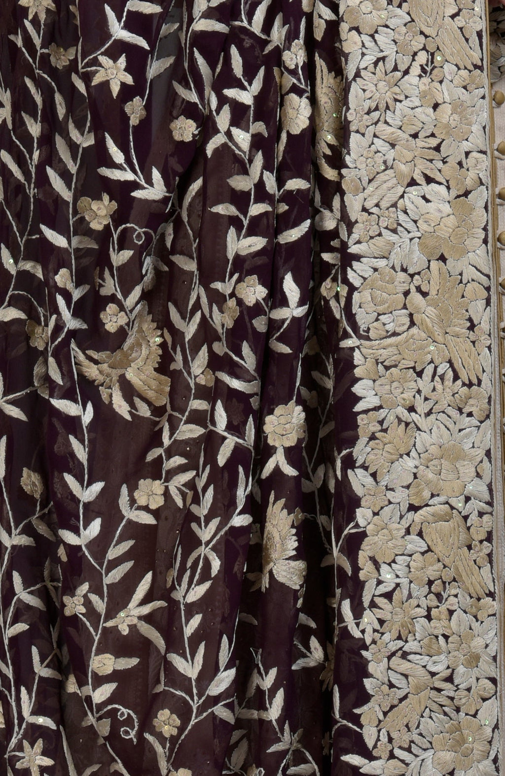 A dark purple fabric with champagne floral and bird embroidery.