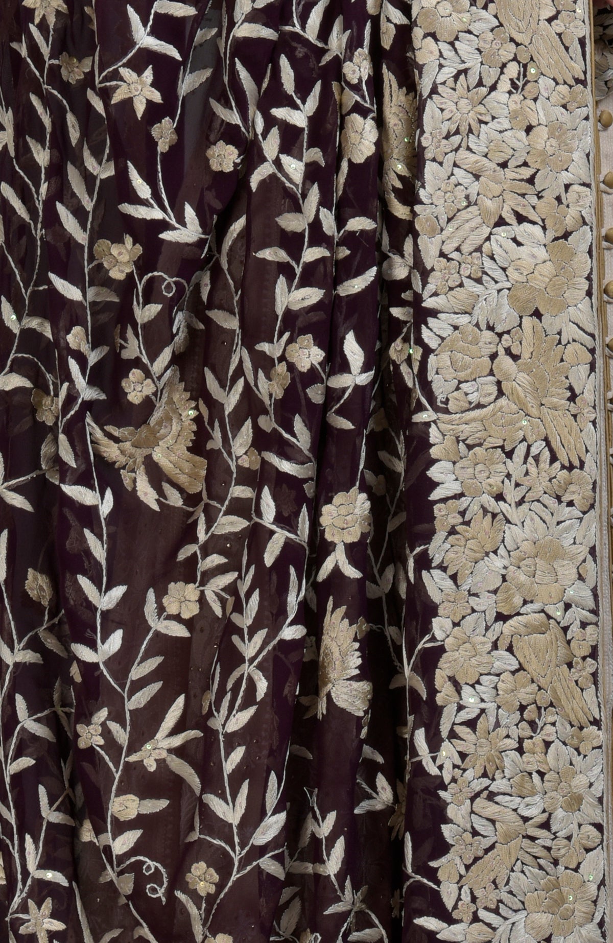 A dark purple fabric with champagne floral and bird embroidery.