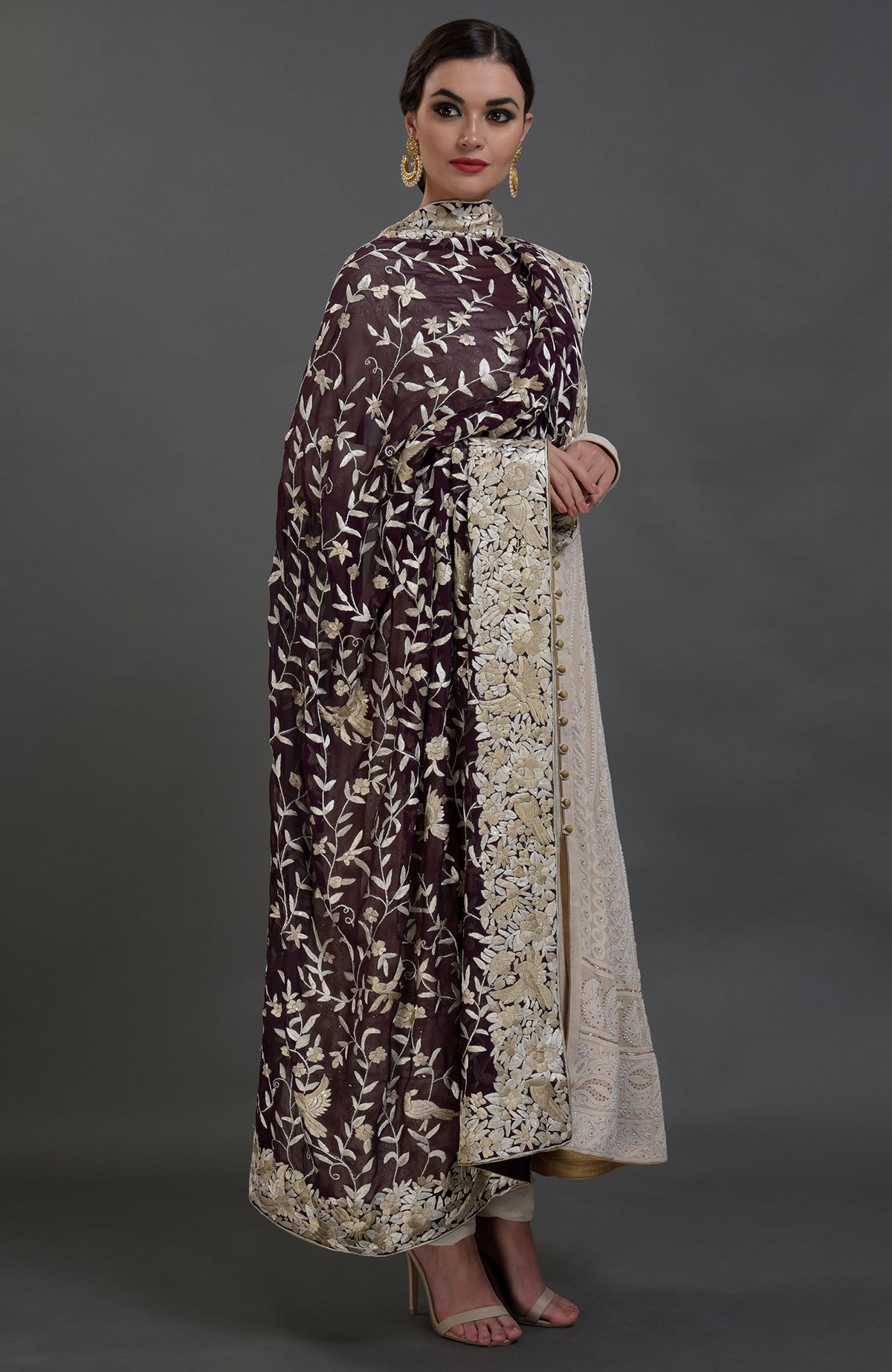 A model wears a champagne chikankari suit with a parsi gara hand-embroidered dupatta.