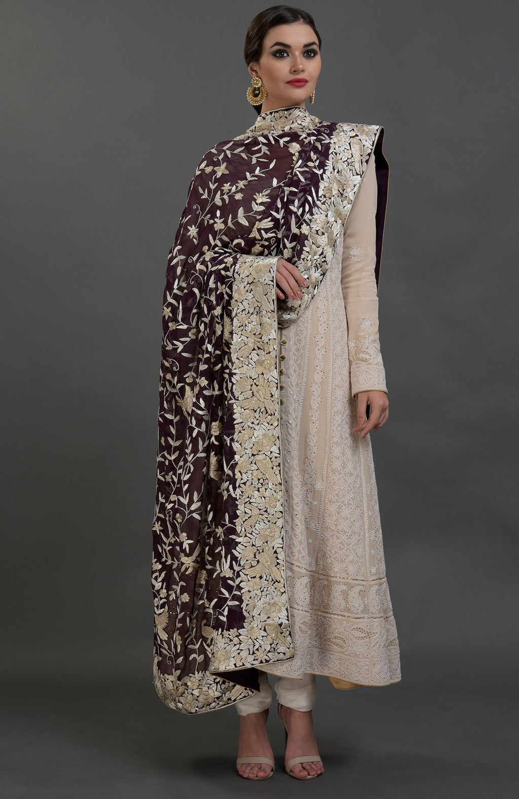 A woman models a champagne chikankari suit with a Parsi Gara hand-embroidered dupatta.